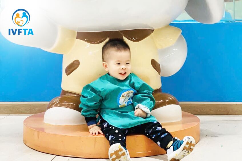 bé trai ivf cười tươi dưới ánh nắng